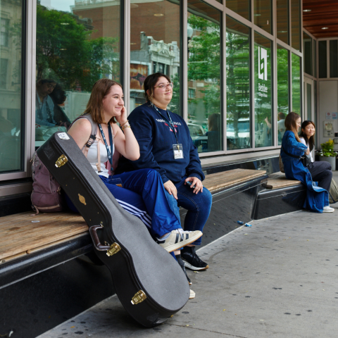 2 girls sitting outside on a bench