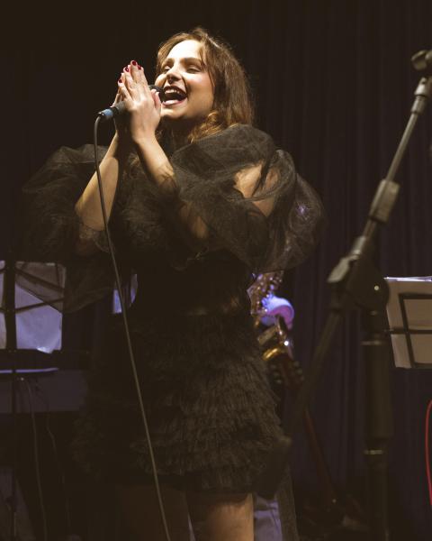 a young woman holding a microphone singing
